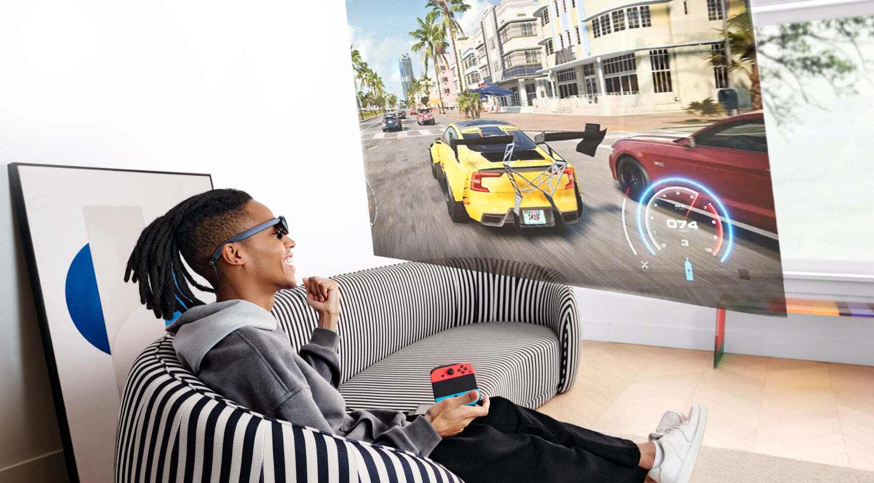 Un homme assis sur le canapé utilisant des lunettes intelligentes Rokid Max AR pour jouer