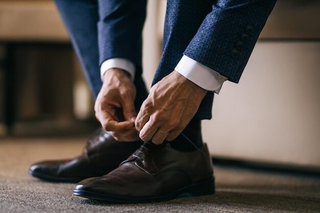 Le marié matin avant la cérémonie de mariage porte des chaussures L'homme d'affaires attache les lacets sur les chaussures Style homme Professions Pour se préparer au travail à la réunion | Photo