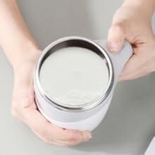 une personne tenant un mixeur avec un pot de lait.