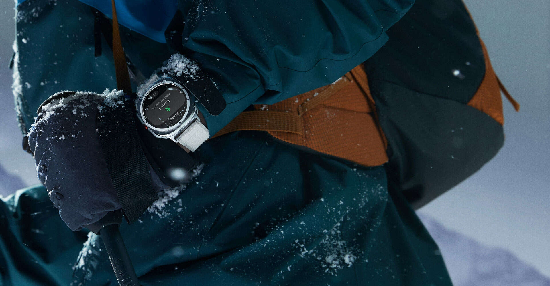 Une personne portant un équipement d’alpinisme, avec un peu de neige dessus, a une Galaxy Watch Ultra au poignet.